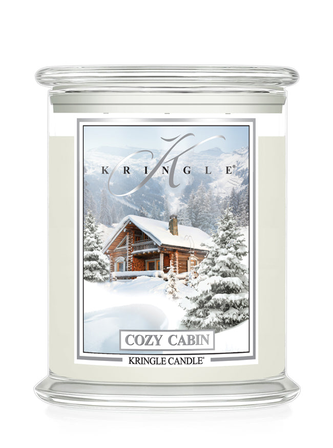 Kringle Candle with a snowy cabin design on a white background